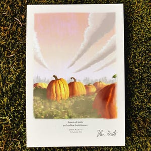 May include: A rectangular art print featuring a pumpkin patch under a pale pink sky with diagonal clouds. Below the illustration, the text reads: Season of mists and mellow fruitfulness... — JOHN KEATS — To Autumn, 1819, followed by the signature John Keats.