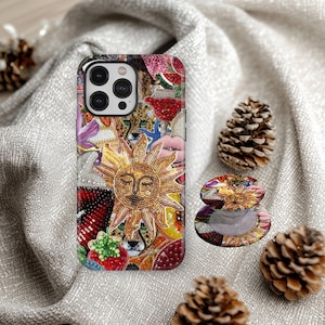 Op de afbeelding: Een decoratieve telefoonhoes en bijpassende telefoonhouder met een zonontwerp en een lachend gezicht, omringd door kleurrijke kralenversieringen. De hoes en houder hebben een collage van verschillende afbeeldingen.