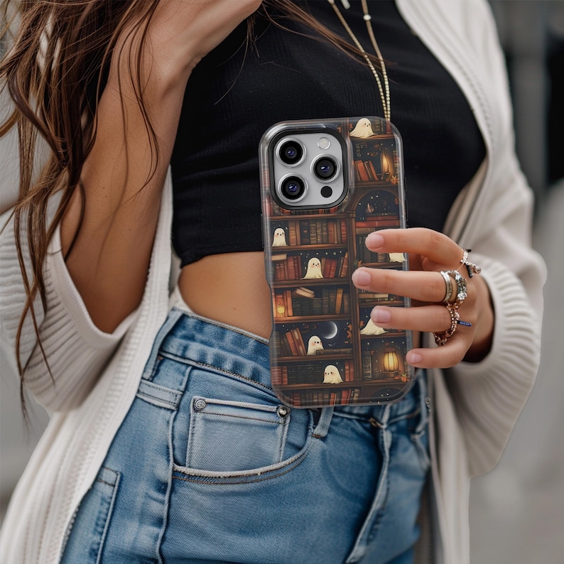Puede incluir: Funda transparente para tel&eacute;fono con un dise&ntilde;o de estanter&iacute;a espeluznante e ilustraciones de fantasmas peque&ntilde;os. La funda tiene un fondo oscuro similar a la madera con libros, una luna y una linterna. La funda est&aacute; dise&ntilde;ada para un tel&eacute;fono inteligente.
