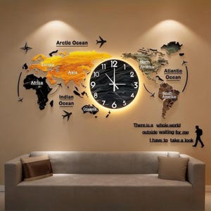 Puede incluir: Un reloj de pared con mapa del mundo con esfera negra y números blancos. El mapa está dividido en continentes con diferentes colores. El texto en la pared dice: "Hay todo un mundo esperando, tengo que echar un vistazo."