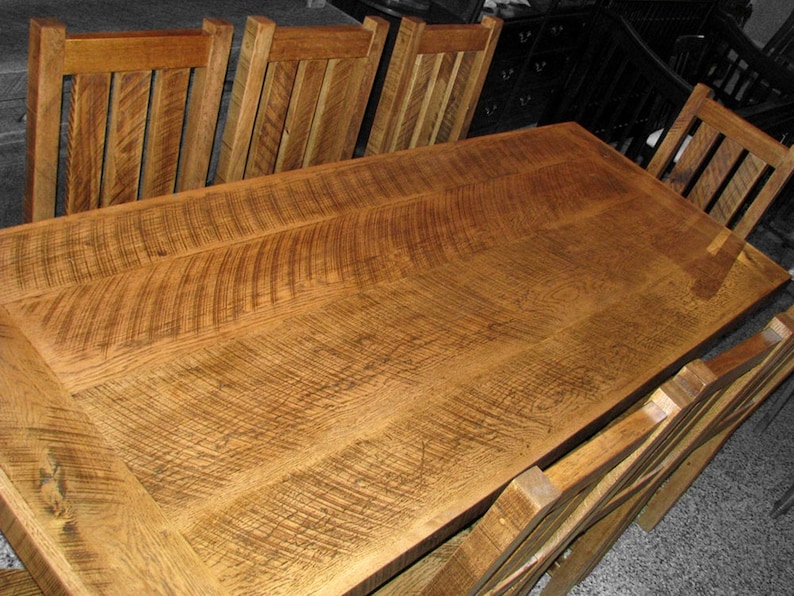 Puede incluir: Una gran mesa de comedor de madera r&uacute;stica con un acabado de madera natural. La mesa est&aacute; rodeada de seis sillas con un acabado de madera similar. La superficie de la mesa tiene un patr&oacute;n de veta &uacute;nico.