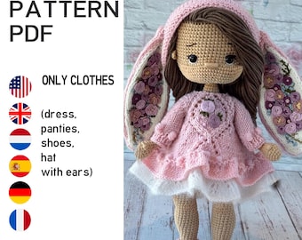 May include: A crocheted doll wearing a pink dress, shoes, and a hooded hat with bunny ears. The doll has brown hair and is holding its arms at its sides. The text "KNIT PATTERN PDF" and "ONLY CLOTHES" is visible.