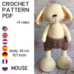 May include: A crocheted mouse toy with a cream-colored body, large ears, and brown shorts. The text "CROCHET PATTERN PDF" and "MOUSE" are visible. The body measures 15.7 inches.