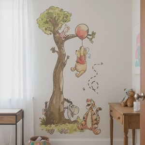 May include: A whimsical wall decal featuring Winnie the Pooh and friends. The illustration shows Pooh hanging from a red balloon, Piglet in a tree, and Tigger and Eeyore on the ground. The artwork is in soft, muted colors, perfect for a nursery or child's room.