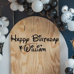 K&ouml;nnte beinhalten: Ein Holzschild mit dem schwarzen Schriftzug &bdquo;Happy Birthday William&ldquo;, umgeben von schwarzen und wei&szlig;en Luftballons, darunter Luftballons in Form von Mickey Mouse. Das Schild hat einen bogenf&ouml;rmigen oberen Rand.