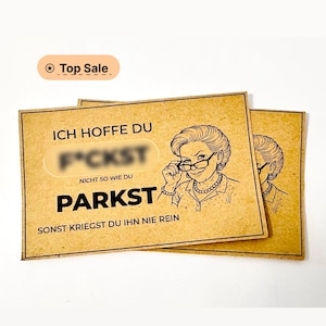Könnte beinhalten: Zwei braune Karten mit einer Cartoon-Illustration einer Frau mit Brille. Die Karten haben deutschen Text, einschließlich der Wörter "PARKST" und "F*CKST". Die Karten sind mit "Top Sale" beschriftet.