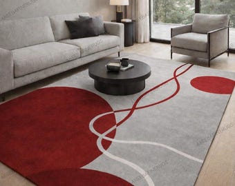 May include: A modern area rug with a gray background and a bold design featuring large red circles and flowing white and red lines. The rug is rectangular and adds a pop of color to a living room setting.