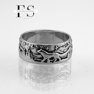 May include: Silver-toned ring with a detailed forest and fox design. The ring features a running fox, trees, and stars, with the text "FLACON SITTANO JEWELRY" in the background. The ring is a wide band style.