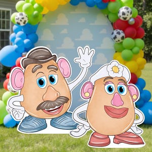May include: Two cardboard cutouts of Mr. and Mrs. Potato Head characters standing in front of a large, arched balloon garland in yellow, blue, green, and red, featuring cow-print balloons and a light blue backdrop with a white cloud pattern.