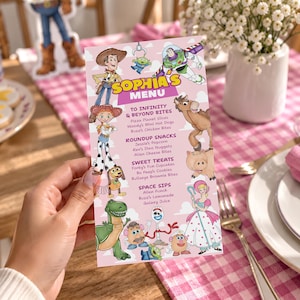 Op de afbeelding: Een rechthoekige roze menukaart met de titel Sophia's Menu en kleurrijke illustraties van Toy Story-personages zoals Woody, Buzz Lightyear, Jessie, Bullseye, Rex en Forky. De tekst bevat voedselcategorieën zoals To Infinity and Beyond Bites.