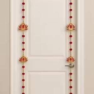 May include: Decorative door hanging featuring a lotus flower design. The hanging has red beads and gold accents. The lotus flowers are red with gold outlines. The door hanging is approximately 60 inches long.