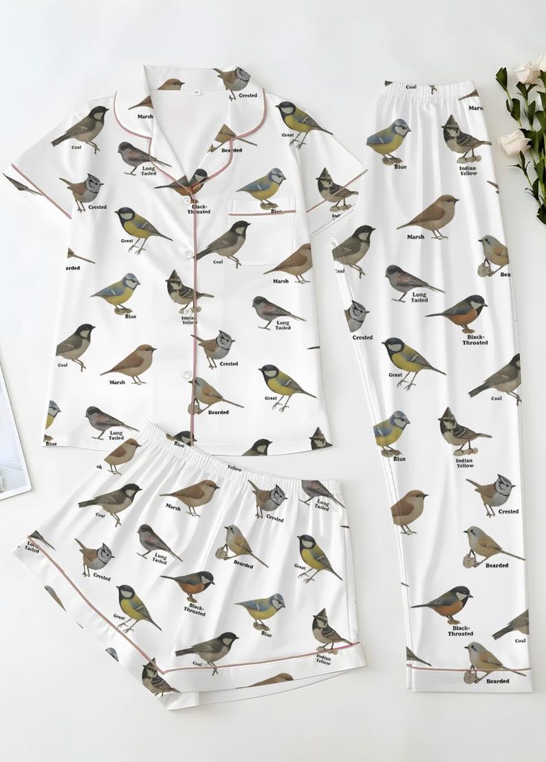 Puede incluir: Conjunto de pijama blanco con estampado de p&aacute;jaros. El conjunto incluye una camisa de manga corta con botones, pantalones cortos y pantalones largos. Cada pieza est&aacute; adornada con ilustraciones de aves y nombres.