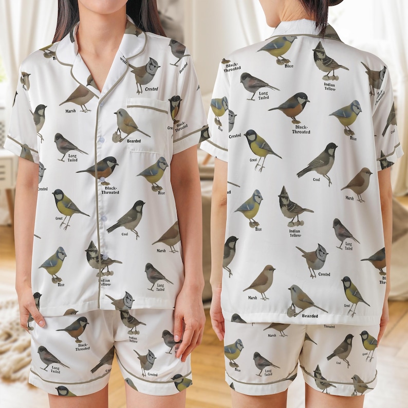 Puede incluir: Conjunto de pijama blanco con estampado de p&aacute;jaros. La parte superior de manga corta y los pantalones cortos presentan varias ilustraciones de p&aacute;jaros con etiquetas. El conjunto tiene una camisa con botones y cuello con solapas y pantalones cortos con cintura el&aacute;stica, ribeteados con un borde marr&oacute;n.