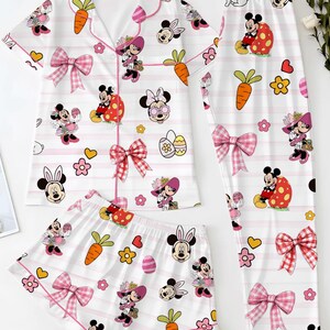 Puede incluir: Un conjunto de pijama de tres piezas con fondo blanco, rayas rosas y dise&ntilde;os de Minnie Mouse. El conjunto incluye una camisa de manga corta, pantalones cortos y pantalones largos, todos adornados con personajes de dibujos animados, zanahorias y lazos.