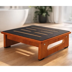 May include: A wooden step stool with a dark, textured top and a warm, reddish-brown finish. The top has several parallel slots. The stool has a rectangular shape and is designed for use in a bathroom or similar setting. The stool measures approximately 12 inches in height.