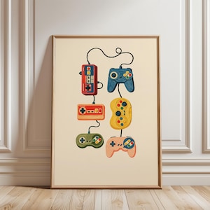 May include: A framed wall art print featuring a vertical arrangement of six vintage-style video game controllers in red, orange, green, blue, yellow, and peach, all connected by black cords against a solid light cream-coloured background.