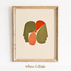 Op de afbeelding: Een ingelijste kunstdruk met een abstracte compositie van twee profielsilhouetten in olijfgroen, geaccentueerd door organische vormen in feloranje en koraal, met een enkel centraal oogdetail op een crèmekleurige achtergrond.