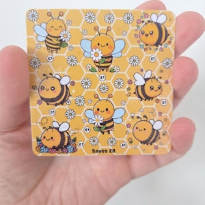 May include: A square yellow savings tracker card featuring a repeating honeycomb pattern with cartoon bees and white daisies. The card includes multiple circular icons labelled with £1 and the text Saves £8 at the bottom centre of the design.