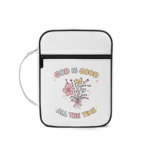 May include: White crossbody bag with a black zip and strap. The bag displays the text "GOD IS GOOD ALL THE TIME" in pastel colours, accompanied by a floral bouquet illustration. Designed for carrying essentials.
