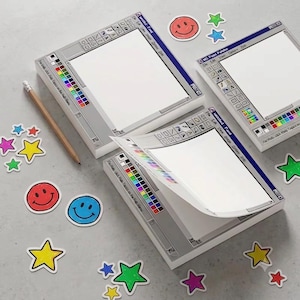 May include: Three square paper notepads featuring a retro computer paint program interface with a white canvas, toolbar, and color palette. The design includes blue title bars labeled Untitled - Paint. Scattered around are colorful star and smiley face stickers.