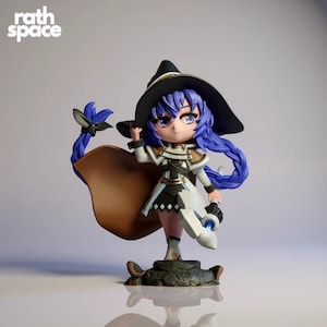 May include: A figurine of a female anime character with blue hair, wearing a black witch hat, white and black outfit, and a brown cape. The figurine is holding a glowing blue orb and is standing on a rocky base. The text "rath space" is in the upper left corner.