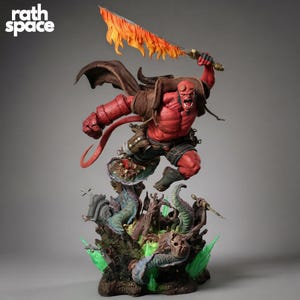 Puede incluir: Estatua detallada del personaje de cómic Hellboy, con piel roja, cola y espada en llamas. Está posando en plena acción, sobre una base detallada con criaturas monstruosas y un tema de cementerio. El logo "rath space" está en la parte superior izquierda.