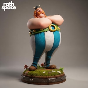 Op de afbeelding: Gedetailleerd beeldje van een stripfiguur met gekruiste armen, een gehoornde helm en een blauw-wit gestreepte broek. Het beeldje staat op een voetstuk met gras, paddenstoelen en bloemen. De tekst "rath space" staat linksboven.