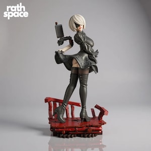 May include: A detailed figurine of a female character in a black dress and thigh-high boots, holding a small device. The figure stands on a red platform. The text "rath space" is in the upper left corner.