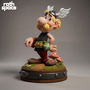 Op de afbeelding: Gedetailleerd beeldje van een stripfiguur met een grote neus, gele snor en gevleugelde helm. Het figuur draagt een zwarte top, rode broek en bruine schoenen. De basis heeft een paddenstoel en de tekst "rath space".