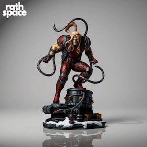 May include: A detailed figurine of a comic book character in a dynamic pose. The figure is clad in a red and brown costume with metallic accents, and has long blonde hair. The figure stands on a detailed base with the text "rath space".