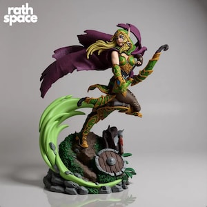 May include: A detailed figurine of a female warrior in a dynamic pose, wearing green and gold armour with a purple cape. The figure is holding a bow and arrow, standing on a rocky base with a shield and axe. The base has green foliage and a light green swirl.