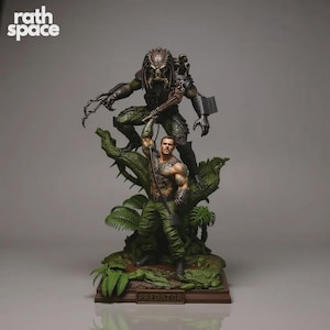 Könnte beinhalten: Eine detaillierte Statue mit einer Predator-Alienfigur, die über einem menschlichen Soldaten thront. Die Figuren sind in Grün-, Braun- und Beigetönen gehalten und stehen auf einem Dschungel-Themen-Sockel. Der Text "PREDATOR" ist auf dem Sockel zu sehen.