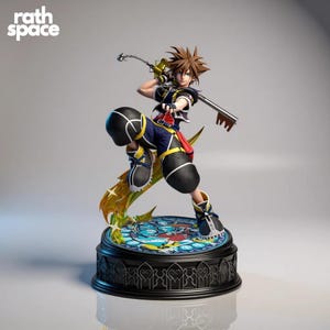 May include: A detailed figurine of a character from the Kingdom Hearts video game series. The figure is posed dynamically, holding a keyblade and chain. The base features a stained-glass design. The Rath Space logo is visible in the upper left corner.
