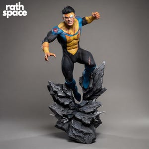 Puede incluir: Estatua detallada de un superhéroe en una pose dinámica, vistiendo un traje negro, amarillo y azul. La figura está de pie sobre una base rocosa, con daños de batalla visibles. El texto "rath space" es visible.