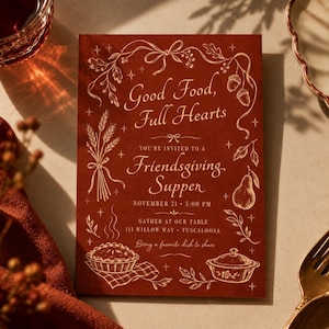 May include: A rectangular dark red invitation card with gold line art illustrations of wheat, acorns, a pear, a pie, and a casserole dish. The text reads: Good Food, Full Hearts, You're invited to a Friendsgiving Supper, November 21, 5:00 PM.