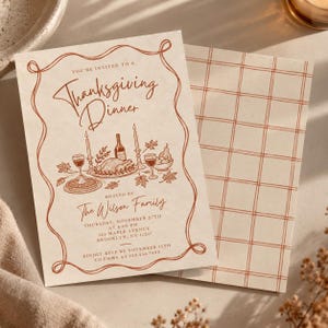 May include: A cream-colored Thanksgiving dinner invitation card with a rust-colored border and line art illustration of a feast. The text reads: You're invited to a Thanksgiving Dinner, hosted by The Wilson Family, Thursday, November 27th.