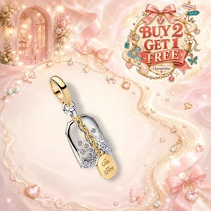 Puede incluir: Un charm de metal en tonos plata y oro con forma de bolsita de té, que presenta cristales transparentes incrustados y una pequeña etiqueta colgante grabada con las palabras Tea Time. Incluye una anilla dorada para su sujeción.
