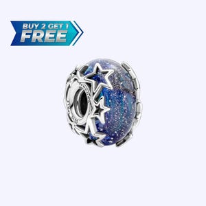 Puede incluir: Un charm de plata con un núcleo azul y blanco moteado, rodeado de estrellas plateadas y una banda plateada. El charm tiene el texto "Pandora" y "S925 ALE". La imagen también incluye una pancarta azul y blanca que dice "BUY 2 GET 1 FREE".