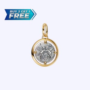 May include: A gold-colored pendant with a circular design. The pendant features a silver-colored coin with an embossed design of two winged figures embracing a shield. The pendant has a loop for a chain and is set against a light background.