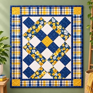 Puede incluir: Una colcha rectangular con un patrón central de cuadrados florales blancos, azul oscuro y amarillos dispuestos en una cuadrícula diagonal. La colcha está enmarcada por un borde de tela a cuadros azul, blanco y amarillo con esquinas amarillas.
