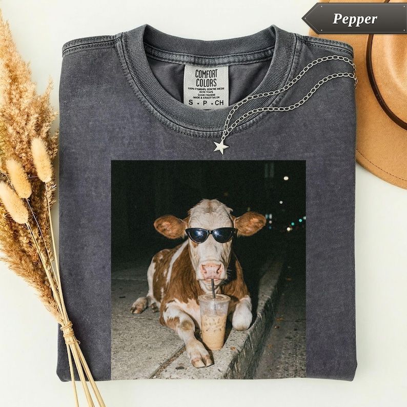 Dark gray t-shirt with a cow wearing sunglasses drinking coffee.