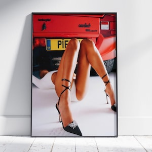 Puede incluir: Impresión enmarcada de un Lamborghini Countach rojo con la matrícula "PIF". La imagen muestra a una persona que lleva zapatos de tacón negros con correas en el tobillo y un body blanco. La parte trasera del coche es visible.