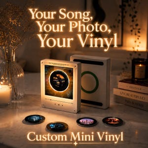 May include: A square, white, illuminated display frame featuring a central circular vinyl record graphic with a photo, accompanied by four small, circular, photo-printed vinyl discs. The frame displays the text "Your Song, Your Photo, Your Vinyl" above and "Custom Mini Vinyl" below.