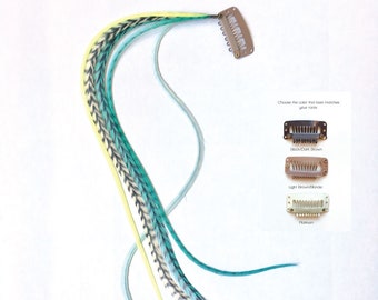 May include: A set of three feather hair extensions in shades of teal, light blue, and yellow. The extensions are attached to a clip that can be used to attach them to hair. The clip is available in three colors: black/dark brown, light brown/blonde, and platinum.