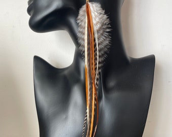 May include: Long, brown, white, and orange feather earrings. The feathers are attached to a silver hook.
