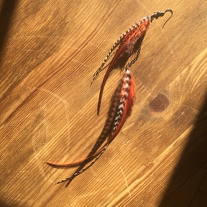 Single long cascading feather earring in burnt orange, rust, black and white stripes. Boho statement, hypoallergenic, handmade, unique. image 3