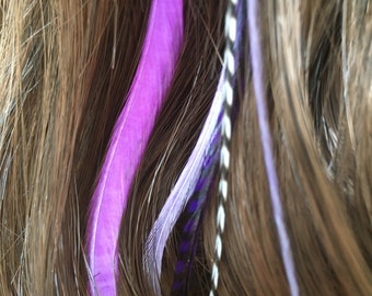 May include: Purple, white, and black feather hair extensions in brown hair.
