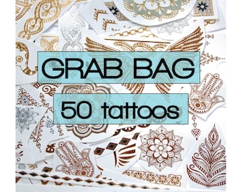 May include: A collection of 50 gold and brown temporary tattoos on a white background. The tattoos feature various designs, including geometric patterns, mandalas, and hand-shaped symbols. The text "Grab Bag 50 tattoos" is printed on the image.