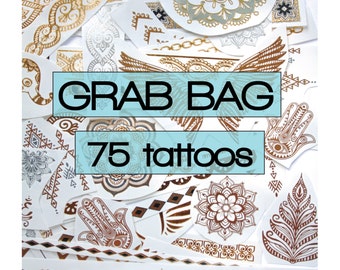 May include: A collection of 75 temporary tattoos with various designs, including henna-style patterns, mandalas, and geometric shapes. The tattoos are in gold, silver, and brown tones, with the words "GRAB BAG" and "75 tattoos" in a blue box.