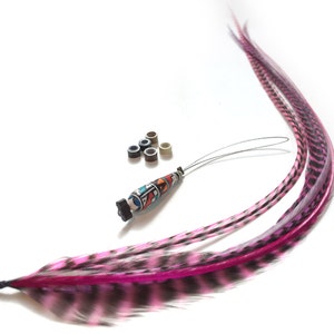Op de afbeelding: Roze en zwarte veren haarverlengingen met een kralenpunt en metalen microringen.